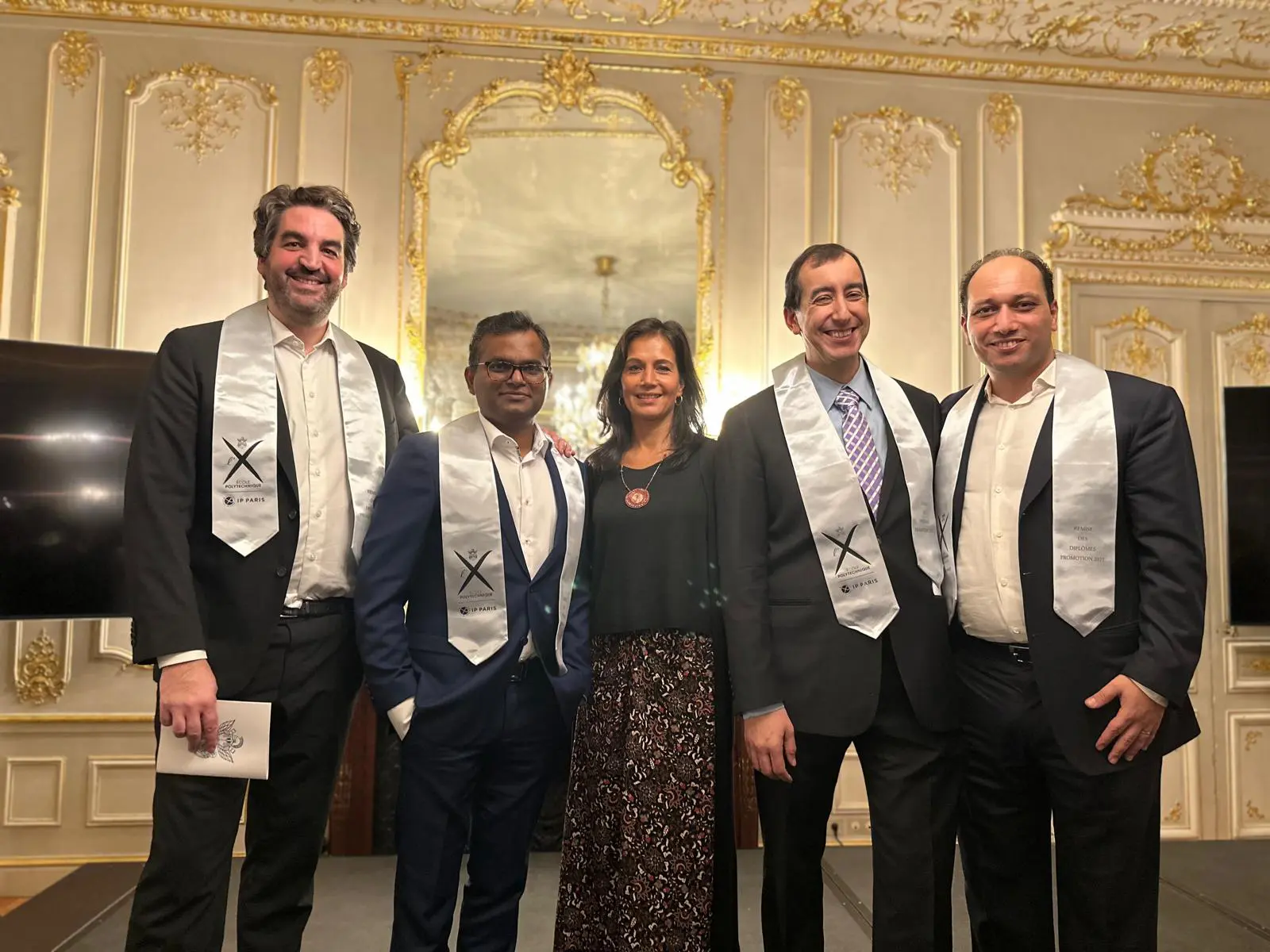 Groupe de personnes en tenue formelle à un événement.