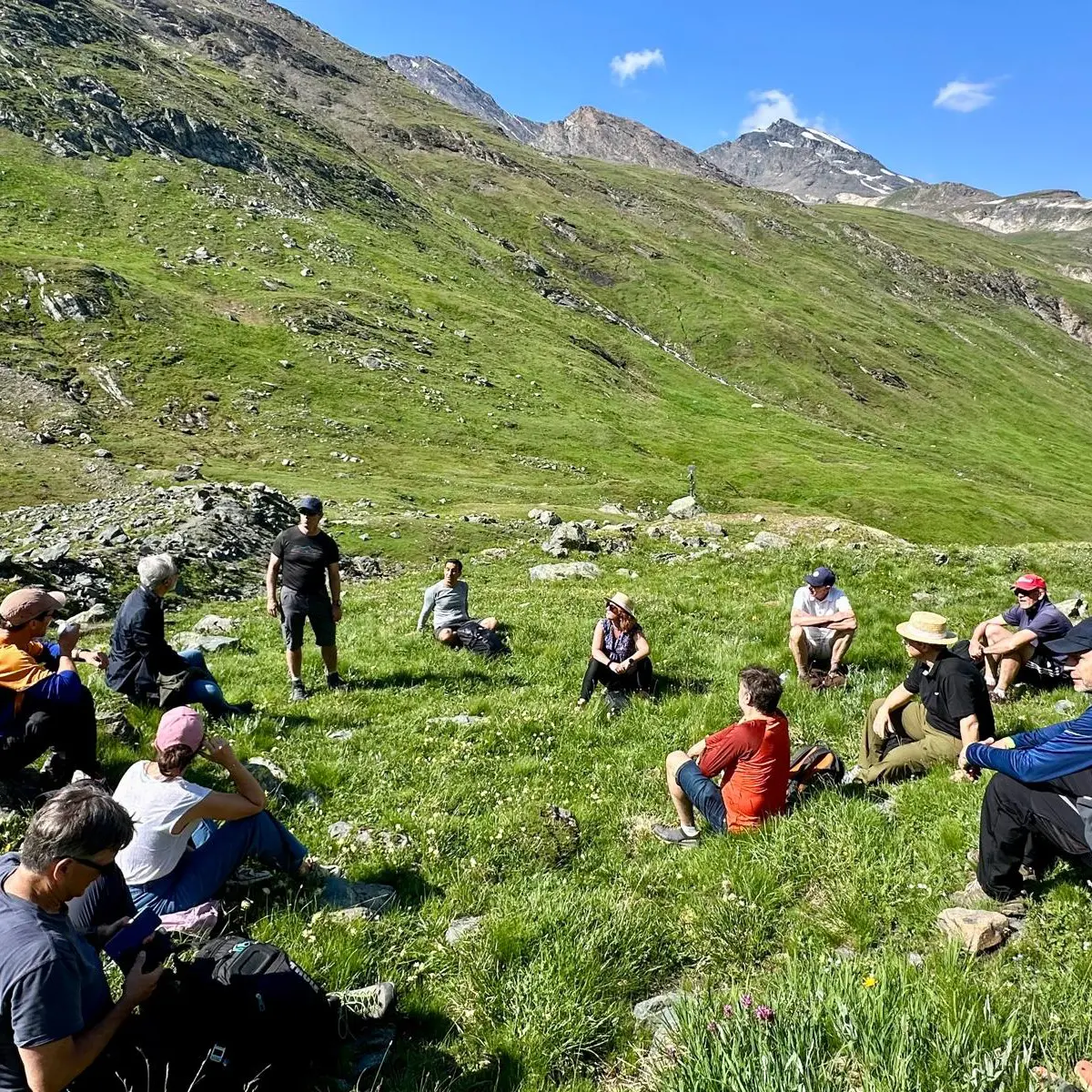 Groupe de randonneurs assis dans les montagnes verdoyantes.