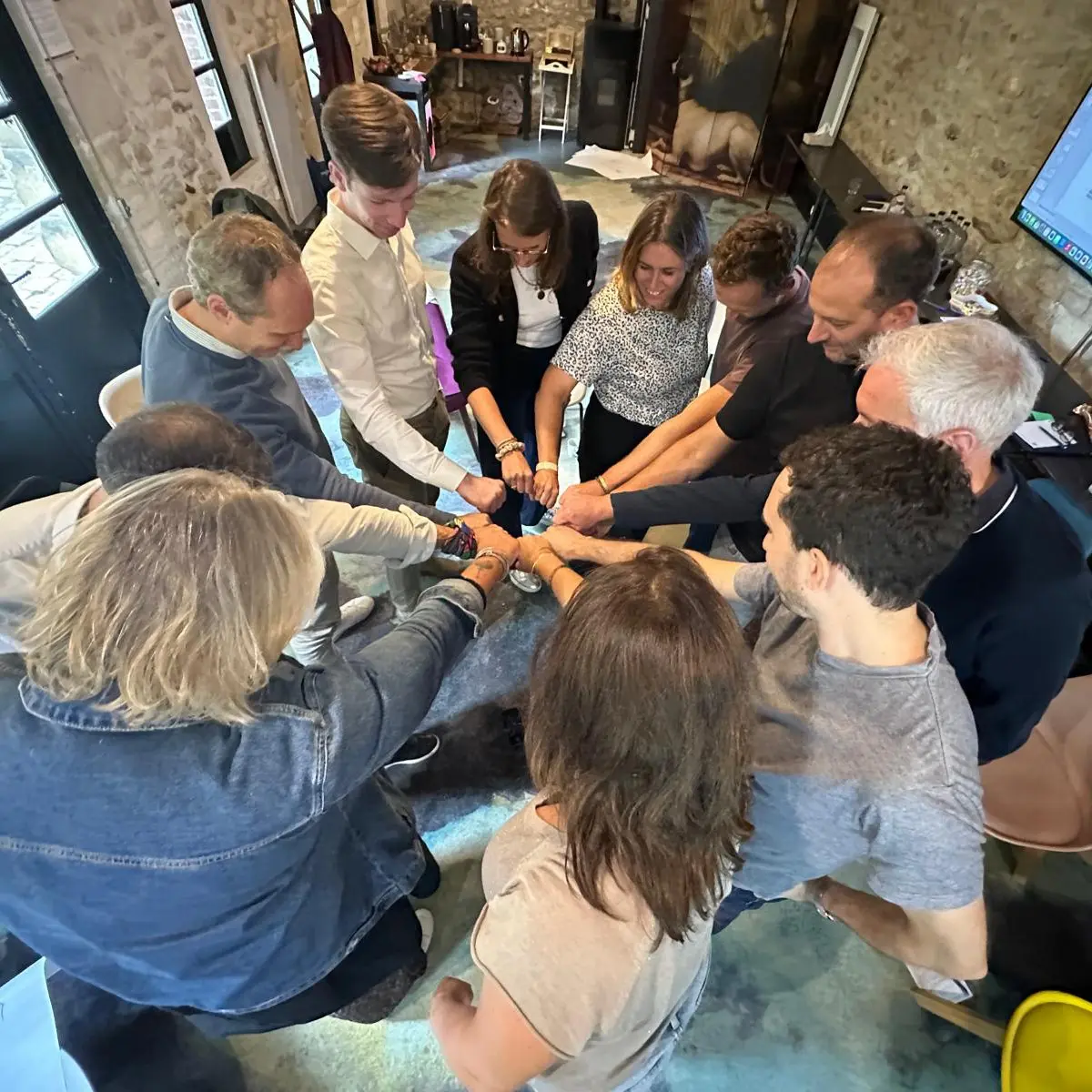 Groupe de personnes se fist-bumpant en cercle.