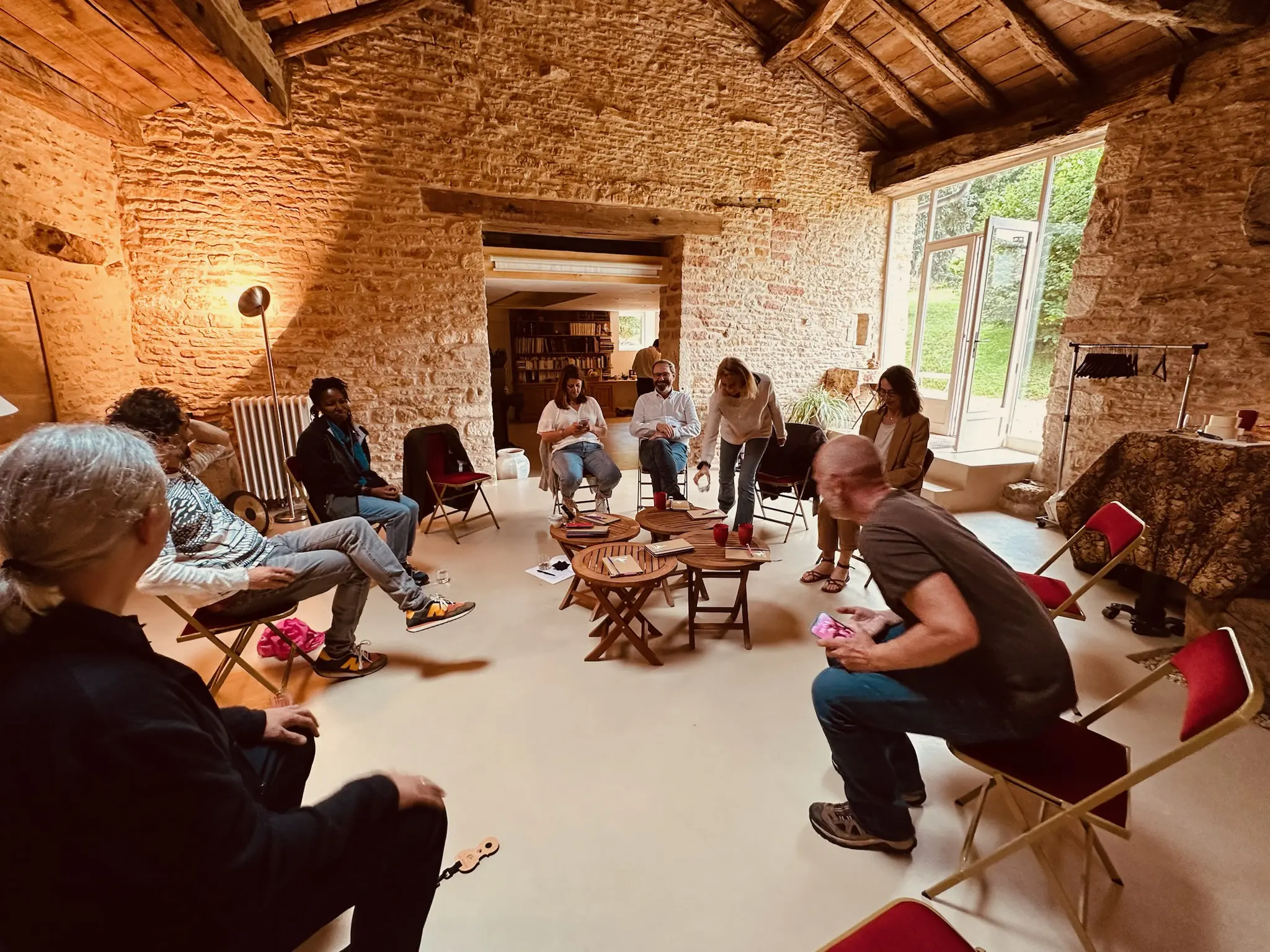 Groupe assis en cercle dans une salle en pierre.