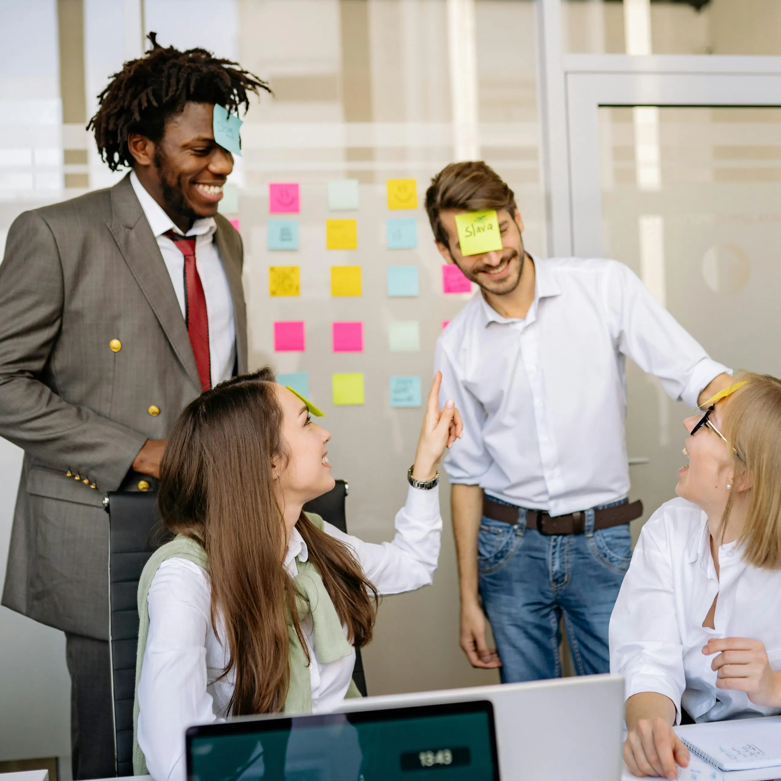 Collègues s'amusant avec des post-its au bureau.