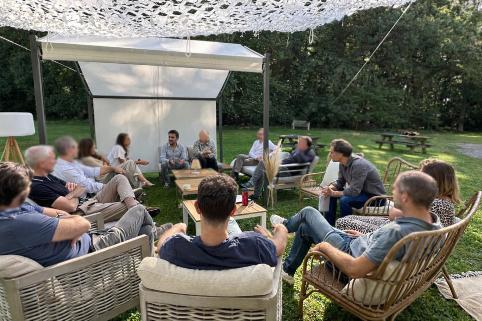 Groupe discutant dans un jardin aménagé.